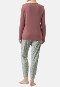 Langarm, rozenkleurig top met ronde hals; bloemenpatroon, mintgroene pyjamabroek met elastische boorden bij de enkels.