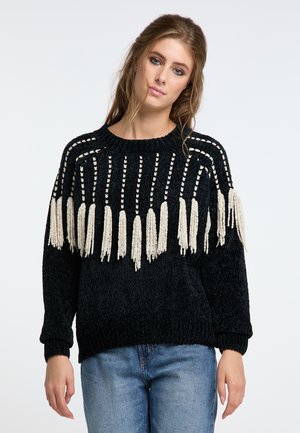 Pulover negru din tricot, cu ciucuri crem pe marginea de jos și un model texturat. Prezintă un guler rotund și mansete cu nervuri. Se potrivește casual.
