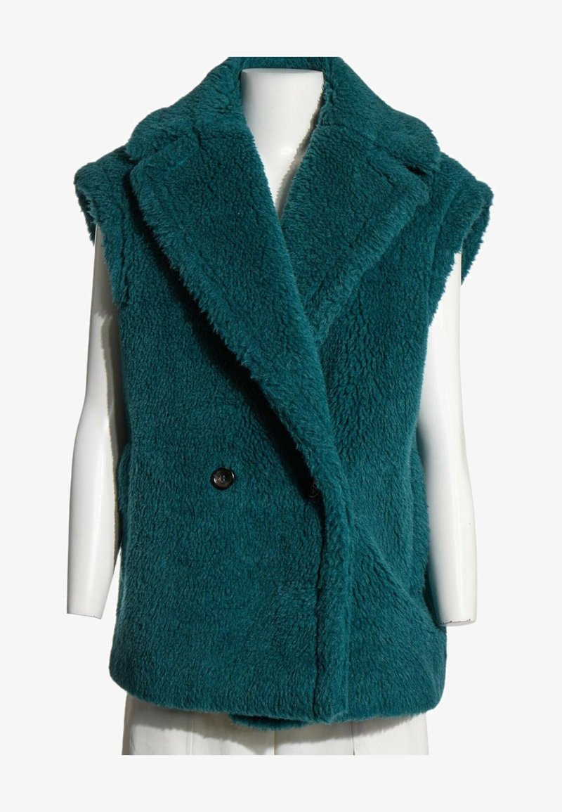Veste sans manches en fausse fourrure bleu sarcelle avec de larges revers et deux boutons noirs, exposée sur un torse de mannequin blanc.