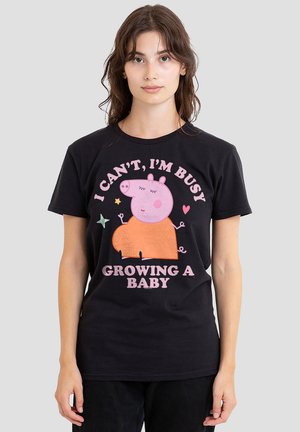 Black cotton t-shirt featuring a cartoon pig graphic in pink and orange, with text that reads, "I CAN'T, I'M BUSY GROWING A BABY."