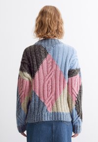 Strickpullover mit einem Patchwork-Design, das aus blauen, rosa, cremefarbenen und grauen Abschnitten besteht. Texturierte Zopfmuster und gerippte Details überall.