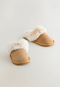 Tan ruskind slippers med fluffy beige faux fur kant, åben rygdesign, holdbar gummisål og en glat overflade på den øverste del.