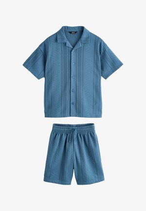 Chemise bleue à manches courtes boutonnée et short assorti à taille élastique avec des motifs subtils de rayures verticales perforées.
