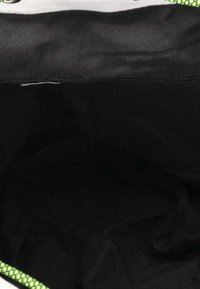 Wnętrze torby z gładką czarną podszewką, z intensywnie zielonym siateczkowym wykończeniem na krawędzi. Brak widocznych kieszeni lub elementów metalowych.