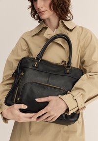 Borsa a tracolla nera in pelle con hardware dorato, dotata di un compartimento principale con zip e tasca frontale. Texture liscia, forma strutturata e manici robusti.