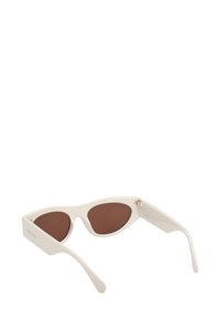 Valkoiset kolmio-muotoiset aurinkolasit ruskeilla linsseillä. Ominaisuuksia ovat kapeat, kaarevat sangan osat ja kultainen yksityiskohta saranassa. Pinta on sileä koko matkalta.