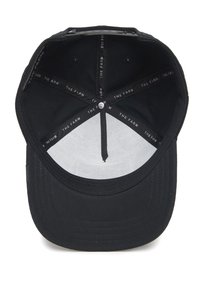 Black baseball cap with a smooth fabric exterior, white lining, and interior branding tape labeled "THE FARM," featuring a circular crown opening.