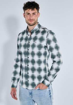 Grün-weiße karierten Hemd mit langen Ärmeln, aus strukturiertem Stoff gefertigt und mit schwarzen Knöpfen, getragen mit hellblauen Jeans.