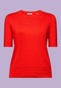 Pull tricoté rouge vif à manches courtes avec col rond et bord-côte sur fond uni violet clair.