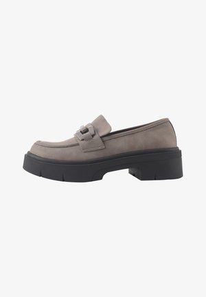 Sivi faux suede loafer s debelom crnom gumom i dekorativnom trakom preko vamp. Ima zaobljen vrh i nisku siluetu.