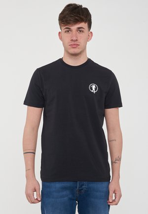 T-shirt nera in cotone concollo rotondo, con un piccolo logo bianco sul lato sinistro del petto e maniche corte. Indossata con jeans in denim blu.