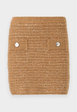 Brun textured strikket skjørt med ribbestrikket liv og to frontlommer med hvite knapper. Subtile glitrende detaljer i stoffet.