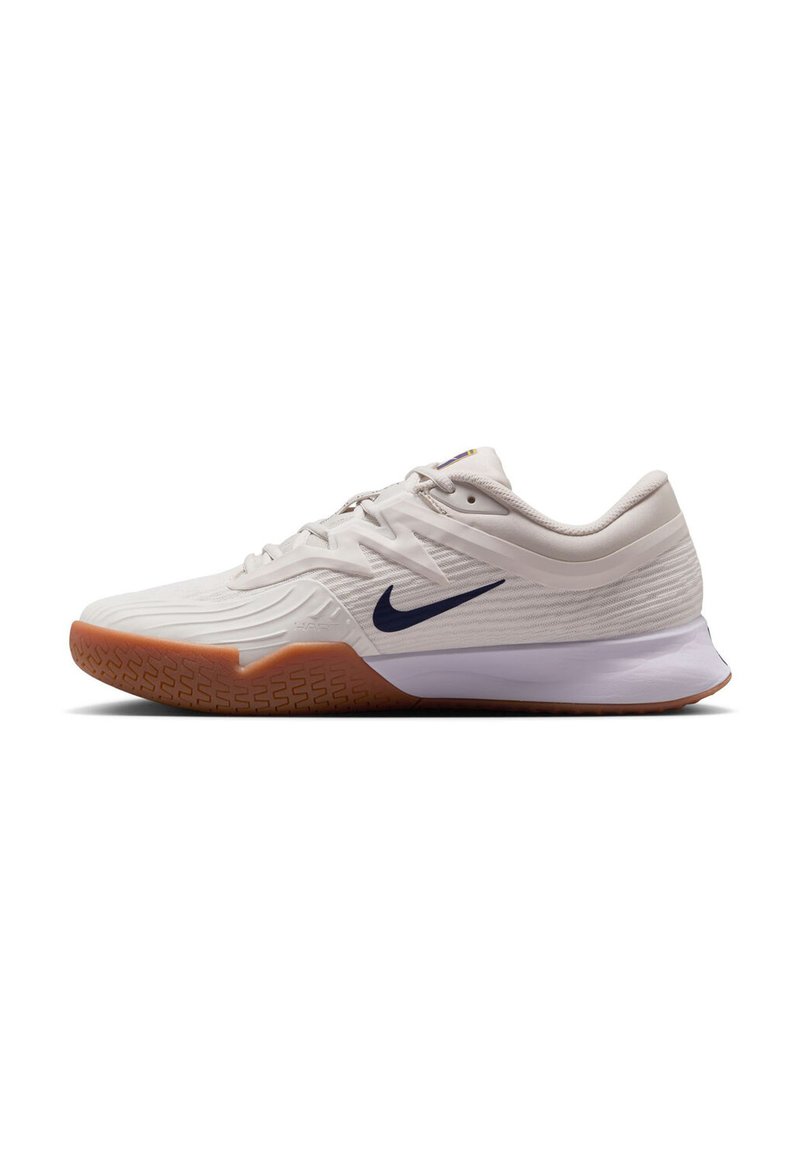 Des chaussures de sport de couleur claire avec une tige texturée, arborant un logo marine bien en vue, une semelle rembourrée et une semelle extérieure en gomme.