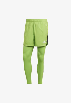 Grüne Sportshorts mit passenden Leggings. Leichtes Material, elastischer Bund, seitliches schwarzes Paneel und weiße Logoakzente.