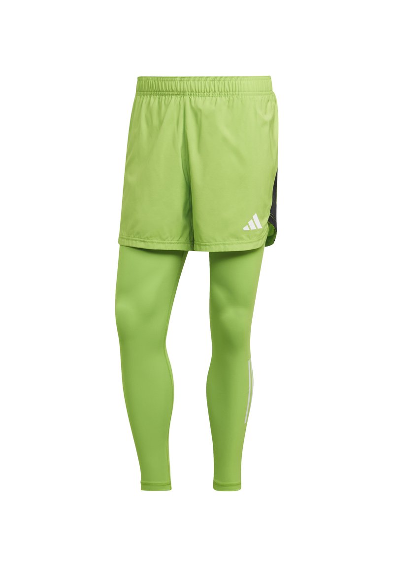 Groene sportieve shorts met bijpassende leggings. Lichtgewicht stof, elastische tailleband, zijpaneel in het zwart en witte logo-accenten.