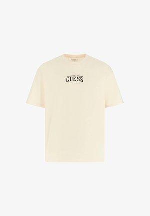 Krátky rukáv, krémové tričko z bavlny s voľným strihom, s čiernym logom "GUESS" a textom na prednej strane.