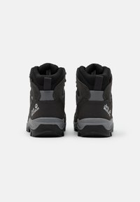 Svarta vandringskängor med grå detaljer, sedda bakifrån, som visar upp varumärkeslogotypen och den robusta designen som är lämplig för utomhusaktiviteter.