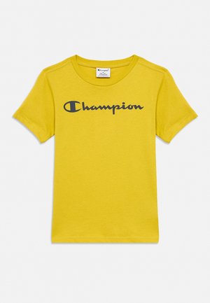 Gul kortærmet T-shirt med sort "Champion" logo trykt over brystet og rund halsudskæring.