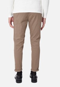 Chino marroni slim-fit con risvolti, realizzati in morbido tessuto di cotone. La vista posteriore mostra la vita e dettagli di cucitura minimi.