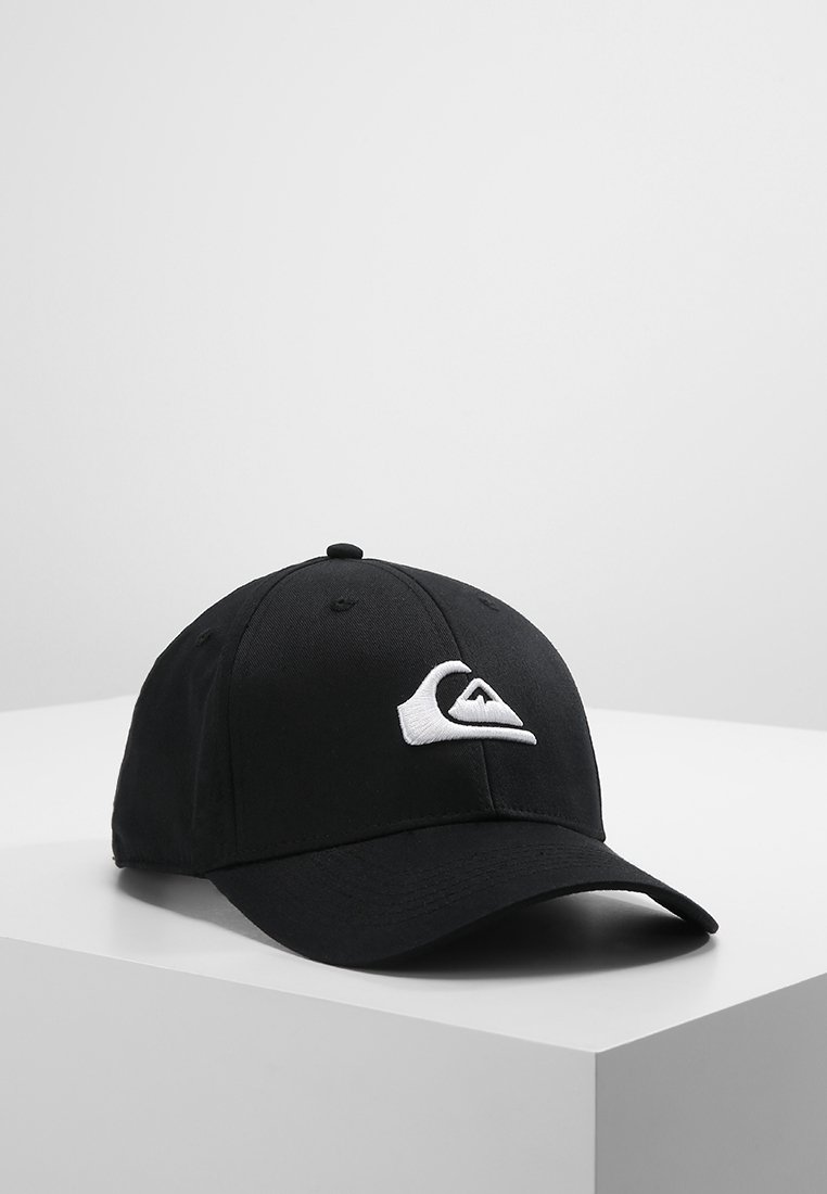 Casquette de baseball noire avec un logo blanc brodé représentant une vague et une montagne sur le devant, posée sur une surface angulaire blanche sur un fond uni.