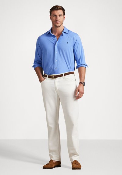 Γαλάζιο πουκάμισο με κουμπιά, άσπρα παντελόνια, καφέ ζώνη και καφέ λόφερ. Λείος ύφασμα με μια διακριτική λογότυπο στο αριστερό μέρος του πουκαμίσου.