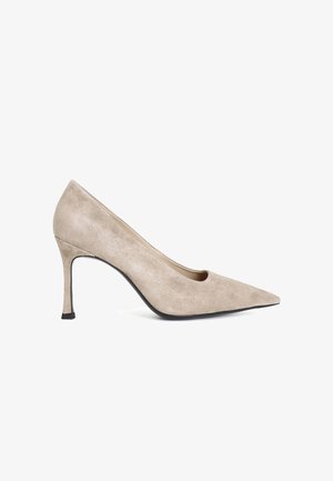 Beige suede hoge hak pump met een spitse neus, 7,5 cm naaldhak en een gladde textuur. Zwarte loopzool accentueert het ontwerp.