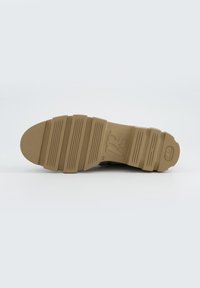 Podeszwa brązowego sneakersa z wyraźnymi rowkami i logo, wykonana z gumy. Gładka faktura i zaokrąglony kształt palców.