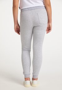 Hellgraue Baumwoll-Sweatpants mit schmalem Schnitt, elastischem Bund und gerippten Bündchen; verfügen über eine Gesäßtasche und eine glatte Textur.
