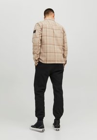 Jack & Jones JPSTKANE JOSH - Tracksuit bottoms - black