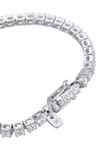 Hõbedane käevõru, millel on ruudukujulised lingid ja selged kalliskivid, kindla lukuga, mis on mõeldud mugavaks kandmiseks. Rikkalikult kaunistatud väikese sildiga.