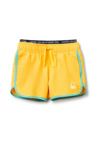 Žluté plavky s černým elastickým páskem setextem "UNITED COLORS OF BENETTON", tyrkysovým lemováním a malým bílým logem.