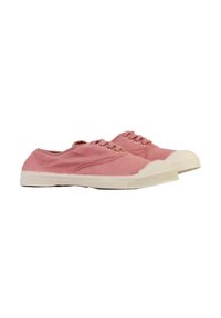 Een paar lage roze canvas sneakers met witte rubberen zolen en neuzen, voorzien van metalen oogjes voor veters, geïsoleerd op een witte achtergrond.
