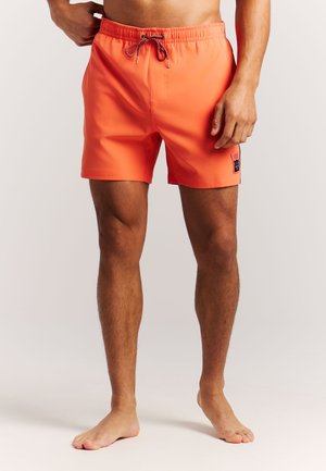 Pantalones cortos de baño de color naranja brillante hechos de tela ligera, con una cintura elástica con cordón y un pequeño logo en el lado izquierdo.
