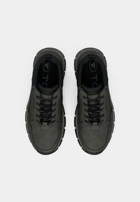 Dunkelgraue Sneakers mit einer glatten Lederoberfläche, schwarzen Schnürsenkeln, gepolstertem Kragen und strukturiertem Gummisohle, die ein minimalistisches Design aufweisen.