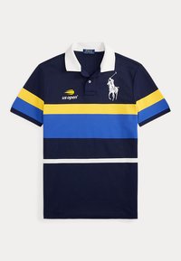 Μπλε ναυτικής απόχρωσης πουκάμισο Polo Ralph Lauren με κίτρινες, μπλε και λευκές οριζόντιες ρίγες, λευκό γιακά, λογότυπο US Open και λευκό έμβλημα παίκτη πόλο.
