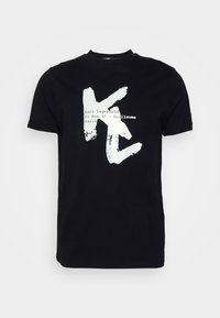 Black cotton T-shirt featuring a white, brushstroke-style "K" logo with text: "Karl Lagerfeld 21 Rue St - Guillaume Paris." Short sleeves, crew neck.