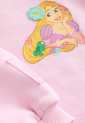 Rosa sweatshirt med en tryckt grafik av en karaktär med långt blont hår, grön kameleont och blommiga detaljer, med strukturerad blomdetalj.