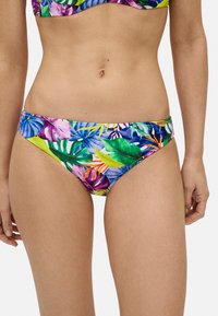 Bikini de fondo con un vibrante patrón de hojas tropicales en colores púrpura, verde y amarillo. Está hecho de una tela suave y elástica con un corte bajo.