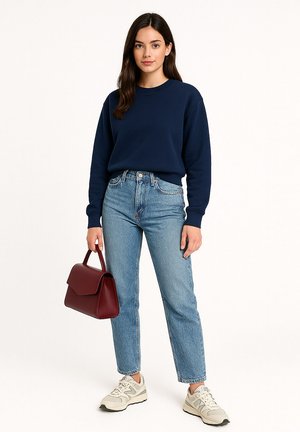 Marineblauwe katoenen sweatshirt, lichtblauwe jeans, beige sneakers en een bordeauxleren handtas. Relaxed fit met geribbelde manchetten.