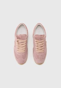 Baskets en suede rose avec lacets beiges, texture lisse, bout rond et semelle en caoutchouc. Présente un petit logo sur le côté.