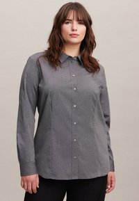 Camicia grigia con colletto, maniche lunghe e una texture sottile; presenta bottoni coordinati e una vestibilità comoda.