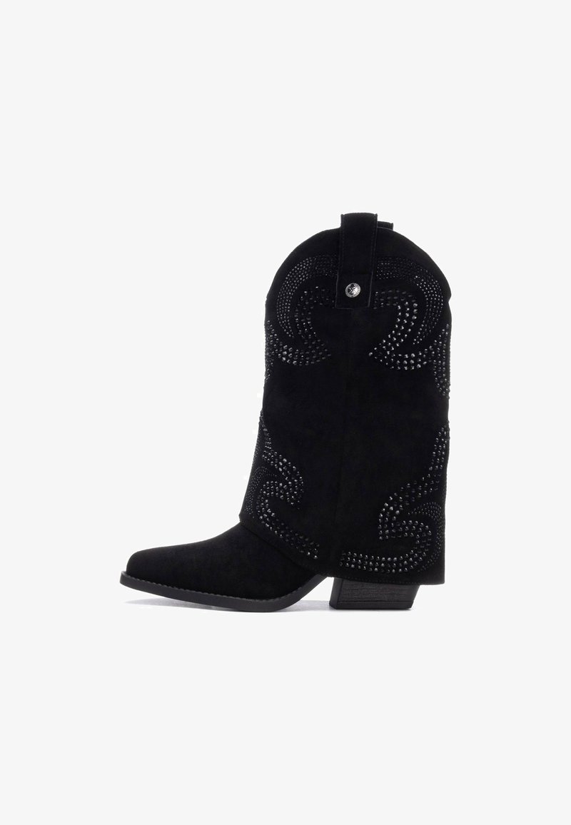 Botas de vaquero de ante negro con punta cuadrada, decoradas con remaches metálicos en un patrón en espiral y un tacón bajo.