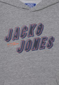 Sweat à capuche gris avec "JACK & JONES" en grandes lettres 3D bleu marine et orange sur la poitrine, avec une petite étiquette de marque à l'intérieur du col.