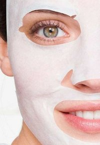 Maschera facciale bianca, che copre la metà inferiore del viso. Texture liscia. Fessure visibili per gli occhi e le labbra. Colore della pelle naturale attorno alla maschera.