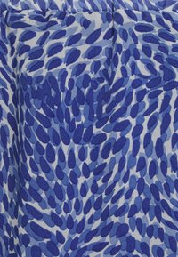 Tecido azul com um padrão de formas abstratas e alongadas em diversas tonalidades de azul, sobre um fundo azul claro. Textura suave.