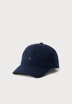 Casquette de baseball bleu foncé à visière incurvée sur fond uni clair.