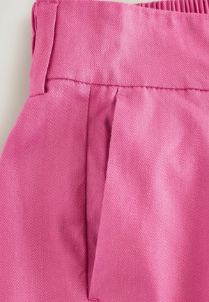 Roze stof met een gestructureerde afwerking, met een geplooid ontwerp en een elastische tailleband voor stretch. Zichtbare stikseldetails op de naden.