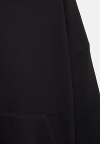 Sort sweatshirt i blødt stof med et enkelt design. Rund halsudskæring, lange ærmer og synlige sømdetaljer.