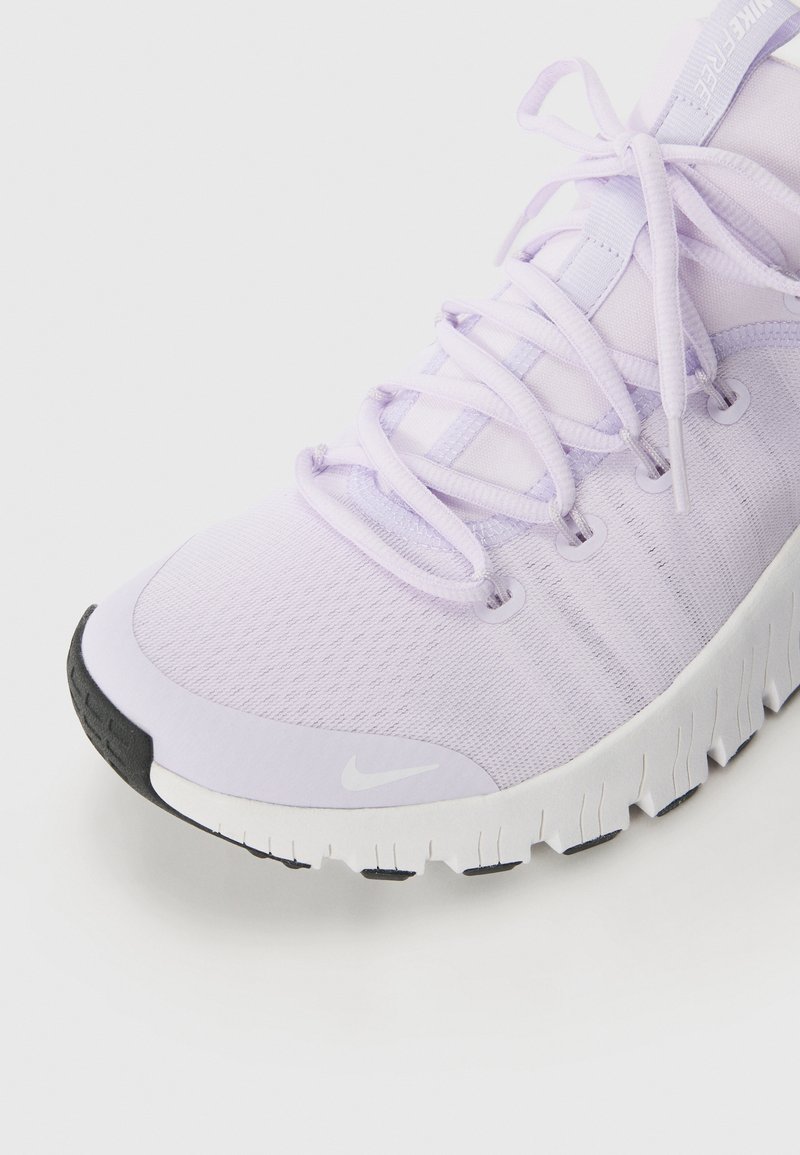 Scarpa da running Nike in tessuto di lavanda chiaro. Presenta lacci rotondi, occhielli rinforzati e una suola in gomma nera texturizzata con accenti bianchi.