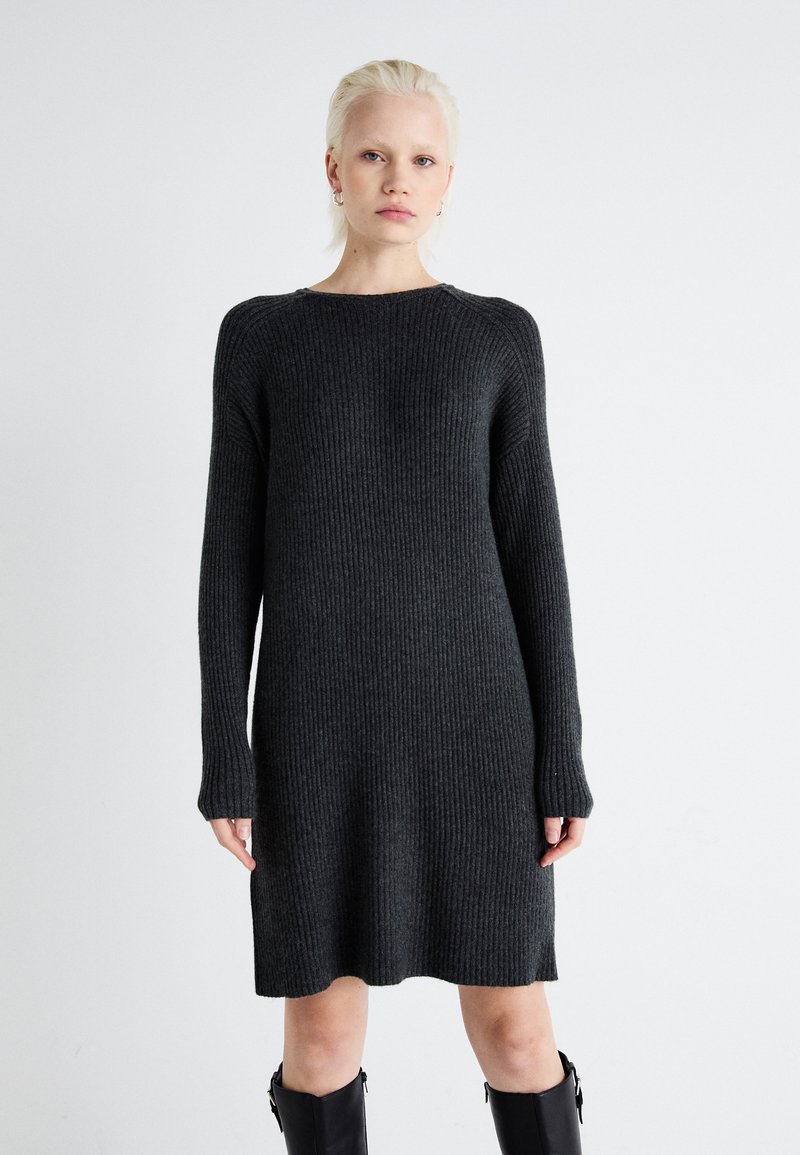 Robe en tricot côtelé gris foncé avec des manches longues, un col rond et une coupe ample, arrivant au mi-cuisse. Tissu texturé avec une légère élasticité.